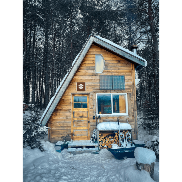 A Winter Recreation Area Symbol sign hung up above a door on a wooden cabin. About us Page Image