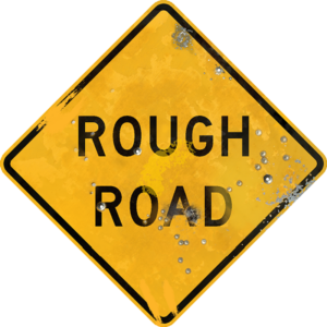 Street Sign with Rough Road legend. Vintage looking sign with digitally printed bullet holes.